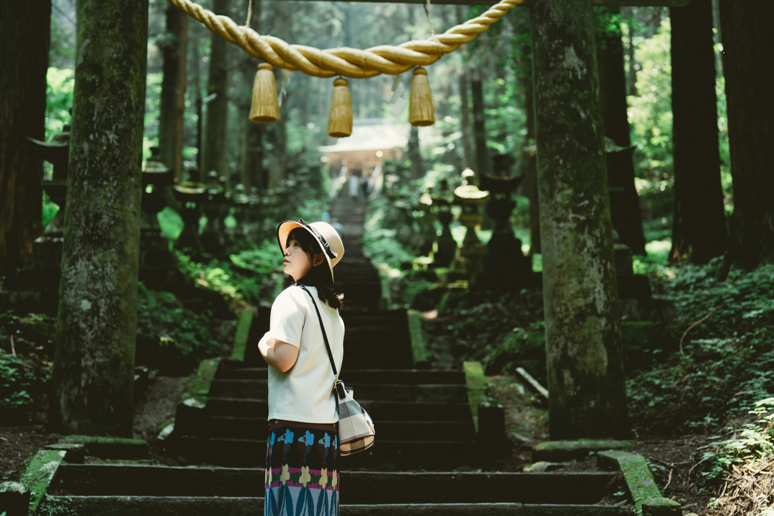 神社の階段を上る女性